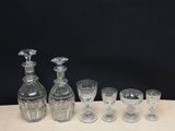 five glasses and a decanter sitting on a table