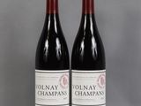 two bottles of red wine sitting on top of a table