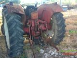 a red tractor that is parked in the grass