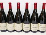 six bottles of red wine are lined up on a white surface