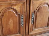 a wooden cabinet with two doors and a drawer