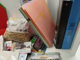 books, pens, and other school supplies sit on a desk