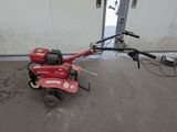 an image of a small tiller in a garage