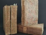 two old books stacked on top of each other on a table