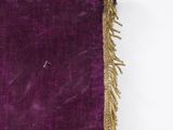 purple velvet with gold fringes hanging on a white wall