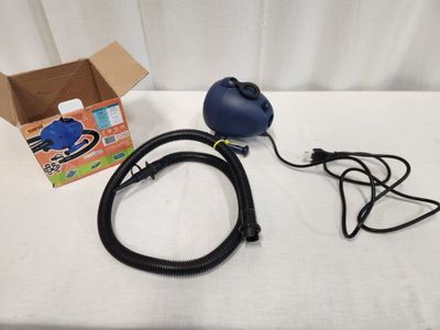 an image of a blue blower sitting on top of a table next to a cardboard box