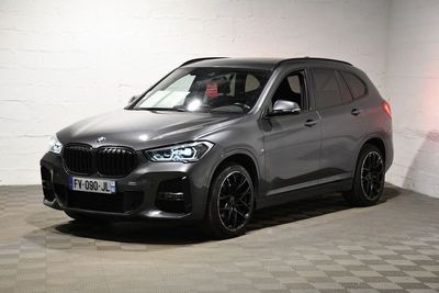La BMW X5 est garée dans un garage dont le sol est en damier.