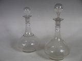 pair of clear glass decanters on a white surface