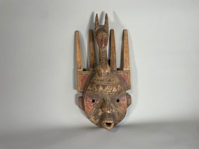 gros plan d'un masque en bois accroché au mur