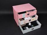 une petite commode rose avec trois tiroirs sur le dessus