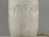 un vase blanc posé sur un socle en bois