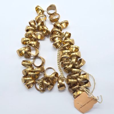 bracelet plaqué or avec des clochettes et une étiquette sur fond blanc