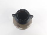 a black and white vase on a white surface