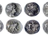 a close up of a bunch of ancient coins on a white surface