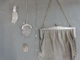 a silver purse with a chain around it on a table