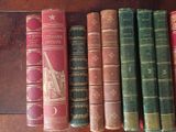 several old books are lined up on a shelf in a row