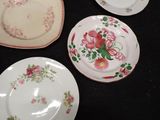 several plates with floral designs are arranged on a black surface