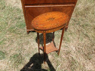 une petite table avec un plateau en bois, posée dans l'herbe