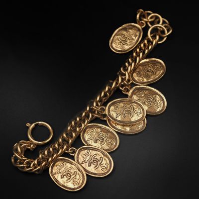 Gros plan sur un bracelet en or orné de pièces de monnaie