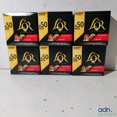 quatre boîtes de chocolats noirs et dorés posées sur un comptoir blanc