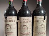 trois bouteilles de vin rouge posées sur une table