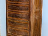 a wooden chest of drawers in a corner of a room