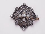 a close up of a diamond broochle on a white surface