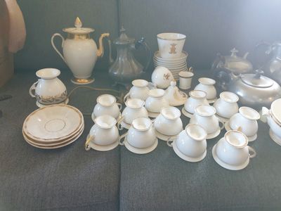 beaucoup de vaisselle blanche et dorée sur la table
