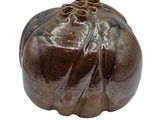 a small brown pumpkin shaped object on a white background