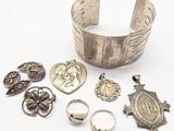 bracelets, bagues et autres bijoux en argent posés sur un fond blanc