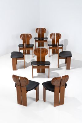 Plusieurs chaises et une table sont disposées en cercle dans une pièce blanche.