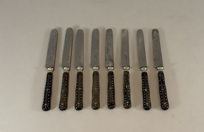 six couteaux sont alignés sur une table