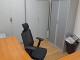 a desk with a computer monitor and a chair in the corner