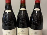 trois bouteilles de vin rouge sont alignées sur une table