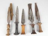 several different types of knives are lined up on a white surface