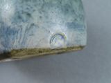 a close up of a blue and white vase on a table