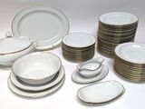 a lot of white and gold plates and bowls on the table