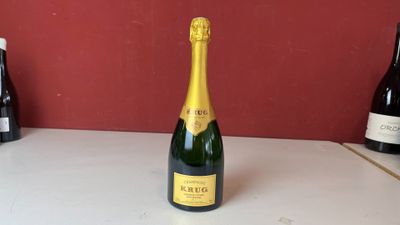 une bouteille de champagne posée sur un comptoir à côté de bouteilles de vin