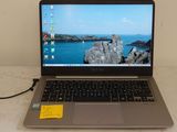 a laptop computer sitting on a table with a yellow sticker on it