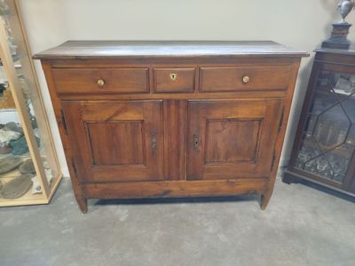 a wooden cabinet with a marble top and a glass door