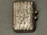 a silver lighter with a floral design on it