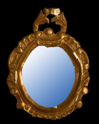 a gold mirror with a bird on it on a black background