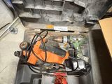 une boîte à outils contenant des outils, posée sur le sol