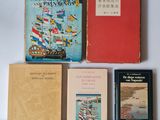 several books sitting on top of a white table next to each other