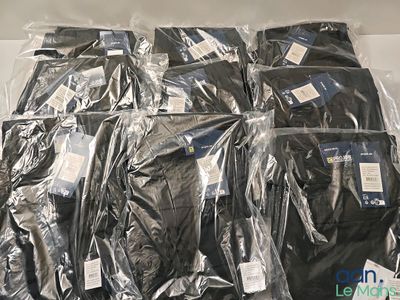 beaucoup de t-shirts noirs emballés dans du plastique, posés sur une table
