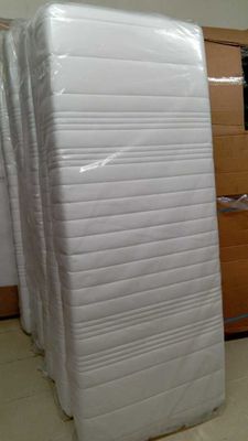 de nombreux matelas empilés les uns à côté des autres dans une pièce