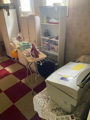 an image of a cluttered room with a desk and a printer