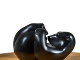 a black sculpture sitting on top of a wooden table