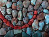 turquoise, red and brown stones are arranged in a pile