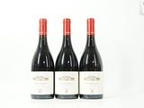 trois bouteilles de vin rouge posées côte à côte sur une table